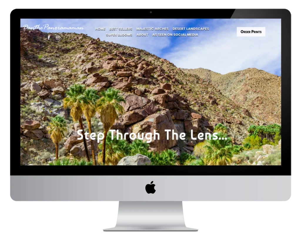 A computer monitor displays a website with a background photo of rocky desert hills, palm trees, and sparse vegetation. The text reads 