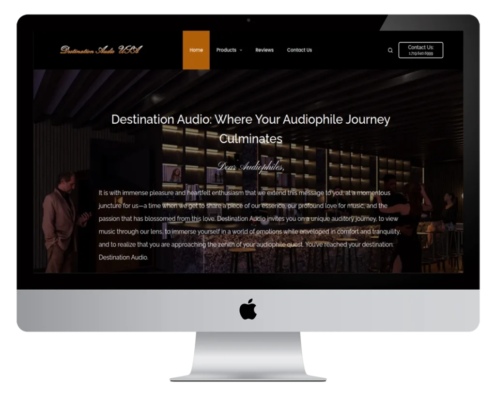 A desktop computer screen displays the Destination Audio 2621 website homepage, featuring a dark theme with white and gold text, navigation menu, and a welcome message describing the site's purpose for audiophiles.