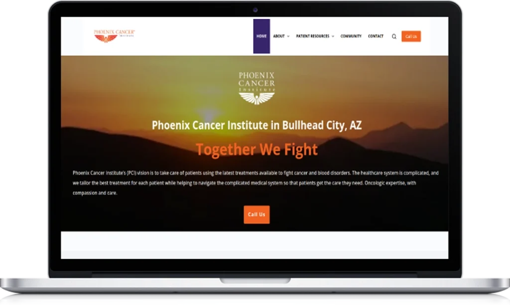 A laptop screen displays the homepage of the Phoenix Cancer Institute website, featuring a sunset background, navigation menu, and text highlighting cancer care services in Bullhead City, AZ.
