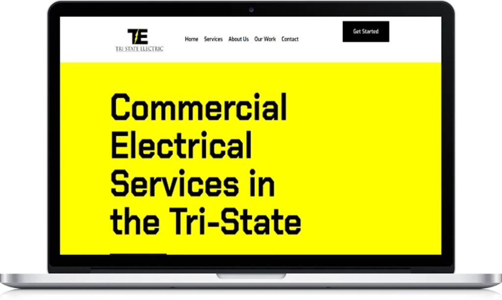 A laptop displays a website with a yellow banner stating 