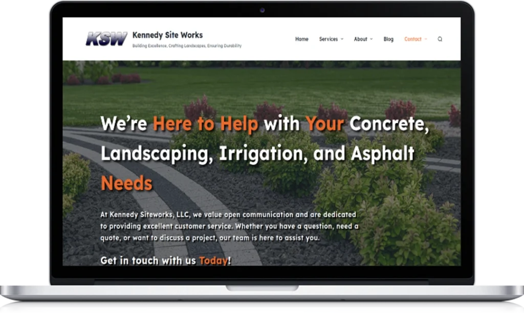 A laptop displays the Kennedy Site Works website homepage, featuring text about concrete, landscaping, irrigation, and asphalt services, with images of landscaped bushes and a navigation menu at the top.