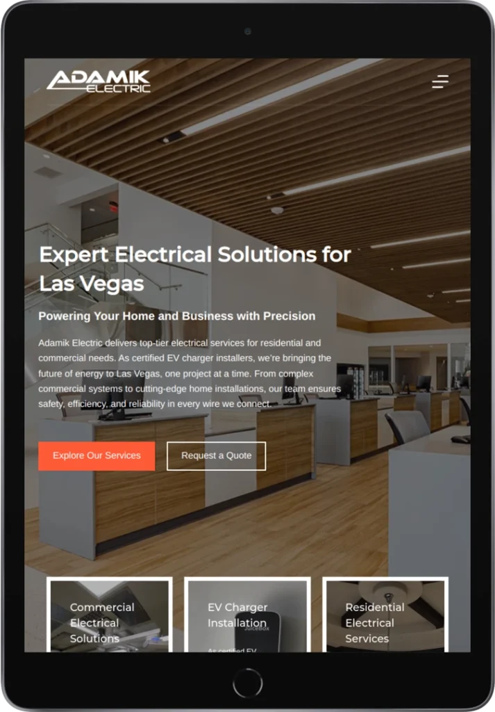 A tablet displays the Adamik Electric website homepage, featuring a modern office interior, company logo, and buttons for 